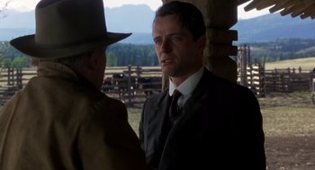 Movie still from “Legends of the Fall” (1994), directed by Edward Zwick – A man wearing a suit and tie talking to another man wearing a suit and tie; Close Up shot, Over the shoulder angle