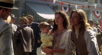 Movie still from “Legends of the Fall” (1994), directed by Edward Zwick – A woman holding a baby while standing next to a crowd; Medium shot, Low angle