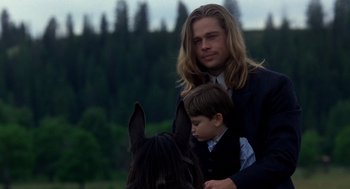 Movie still from “Legends of the Fall” (1994), directed by Edward Zwick – A man and a boy are standing next to a horse; Medium shot, Over the shoulder angle