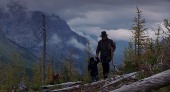 Movie still from “Legends of the Fall” (1994), directed by Edward Zwick – A man and a child walking on a trail in the mountains; Wide shot, Low angle
