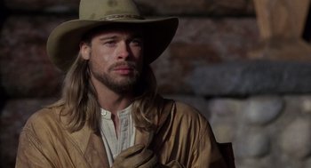 Movie still from “Legends of the Fall” (1994), directed by Edward Zwick – A man with long blonde hair wearing a cowboy hat; Close Up shot, Over the shoulder angle
