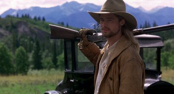Movie still from “Legends of the Fall” (1994), directed by Edward Zwick – A man holding a rifle in his hand; Medium shot, Low angle