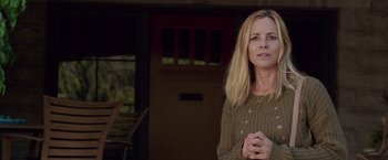 Movie still from “Lights Out” (2016), directed by David F. Sandberg – A woman standing in front of a door wearing a sweater; Medium shot, Low angle