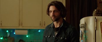 Movie still from “Lights Out” (2016), directed by David F. Sandberg – A man with long hair standing in front of a counter; Close Up shot, Over the shoulder angle