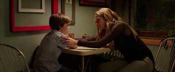 Movie still from “Lights Out” (2016), directed by David F. Sandberg – A woman and a boy sitting at a table; Medium shot, Over the shoulder angle