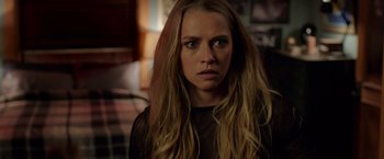 Movie still from “Lights Out” (2016), directed by David F. Sandberg – A woman with long blonde hair stares into the camera; Close Up shot, Over the shoulder angle