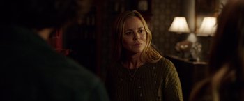 Movie still from “Lights Out” (2016), directed by David F. Sandberg – A woman in a green sweater looking at the camera; Close Up shot, Over the shoulder angle
