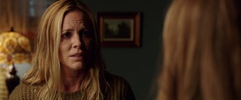 Movie still from “Lights Out” (2016), directed by David F. Sandberg – A woman looking at a mirror in a room with a painting on the wall; Close Up shot, Over the shoulder angle
