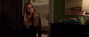 Movie still from “Lights Out” (2016), directed by David F. Sandberg – A beautiful young woman standing in a room; Medium shot, Over the shoulder angle