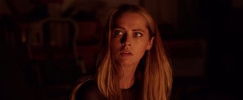 Movie still from “Lights Out” (2016), directed by David F. Sandberg – A beautiful young lady with long blonde hair and green eyes; Close Up shot, Over the shoulder angle