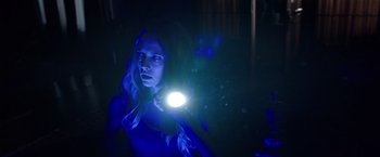 Movie still from “Lights Out” (2016), directed by David F. Sandberg – A woman is holding a flashlight in a dark room; Close Up shot, Over the shoulder angle