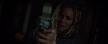 Movie still from “Lights Out” (2016), directed by David F. Sandberg – A woman is holding a gun in a dark room; Close Up shot, Over the shoulder angle