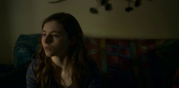 Movie still from “Lost Girls” (2020), directed by Liz Garbus – A woman is looking at the camera in a dark room; Close Up shot, Low angle