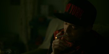 Movie still from “Lost Girls” (2020), directed by Liz Garbus – A man in a hat is smoking a cigarette; Close Up shot, High angle