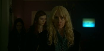 Movie still from “Lost Girls” (2020), directed by Liz Garbus – A woman standing next to another woman in a dark room; Close Up shot, Low angle
