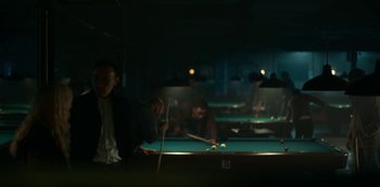 Movie still from “Lost Girls” (2020), directed by Liz Garbus – Two men playing pool in a dark room; Medium shot, Low angle