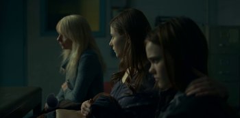 Movie still from “Lost Girls” (2020), directed by Liz Garbus – A group of people sitting in a room; Medium shot, Over the shoulder angle