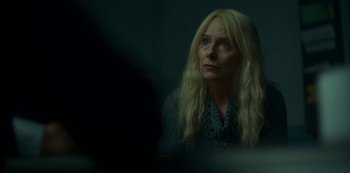 Movie still from “Lost Girls” (2020), directed by Liz Garbus – A woman with long blonde hair stares into a mirror; Close Up shot, Over the shoulder angle