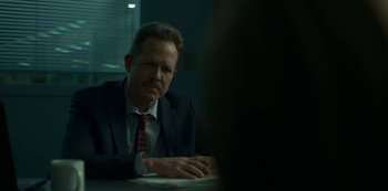 Movie still from “Lost Girls” (2020), directed by Liz Garbus – A man sitting at a table in front of a laptop; Close Up shot, Over the shoulder angle