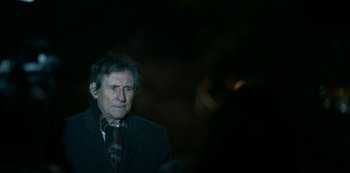 Movie still from “Lost Girls” (2020), directed by Liz Garbus – An older man wearing a jacket and a scarf; Close Up shot, Over the shoulder angle