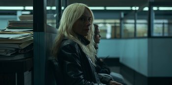 Movie still from “Lost Girls” (2020), directed by Liz Garbus – A woman sitting on a bus with a blonde hair style; Close Up shot, Low angle