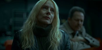 Movie still from “Lost Girls” (2020), directed by Liz Garbus – A woman with long blonde hair wearing a black jacket; Close Up shot, Low angle