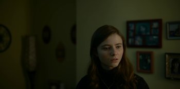 Movie still from “Lost Girls” (2020), directed by Liz Garbus – A young girl in a black shirt is looking at the camera; Close Up shot, Over the shoulder angle