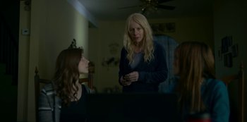 Movie still from “Lost Girls” (2020), directed by Liz Garbus – Two women in a living room one of them is holding a cell phone; Medium shot, Over the shoulder angle