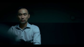 A man in a blue shirt is looking to his left