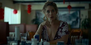 Movie still from “Lost Girls” (2020), directed by Liz Garbus – A woman sitting at a table with a glass in her mouth; Close Up shot, Over the shoulder angle