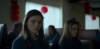 Movie still from “Lost Girls” (2020), directed by Liz Garbus – Two young women sitting in front of a window; Close Up shot, Over the shoulder angle