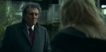 A man wearing a suit and tie talking to a woman wearing a suit and tie