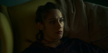 Movie still from “Lost Girls” (2020), directed by Liz Garbus – A person sitting on a couch; Close Up shot, Low angle