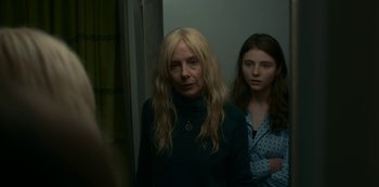 Movie still from “Lost Girls” (2020), directed by Liz Garbus – Two women standing next to each other in front of a wall; Close Up shot, Over the shoulder angle