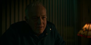 Movie still from “Lost Girls” (2020), directed by Liz Garbus – An older man is sitting in a dark room; Close Up shot, Over the shoulder angle