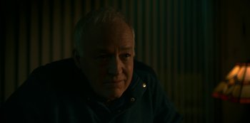 Movie still from “Lost Girls” (2020), directed by Liz Garbus – An older man with white hair is looking at the camera; Close Up shot, Over the shoulder angle