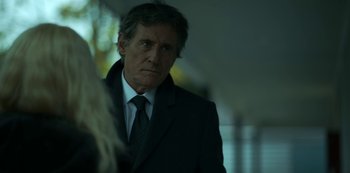 Movie still from “Lost Girls” (2020), directed by Liz Garbus – A man wearing a suit and tie looking at a woman; Close Up shot, Over the shoulder angle