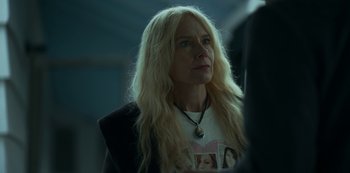 Movie still from “Lost Girls” (2020), directed by Liz Garbus – A woman with long blonde hair wearing a necklace; Close Up shot, Over the shoulder angle