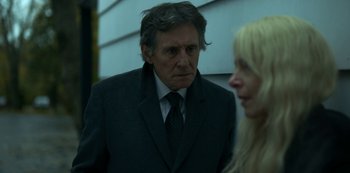 Movie still from “Lost Girls” (2020), directed by Liz Garbus – A man in a suit standing next to a woman; Close Up shot, Over the shoulder angle