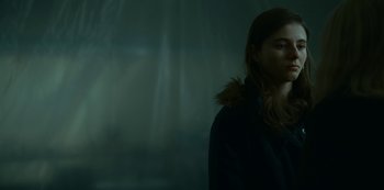 Movie still from “Lost Girls” (2020), directed by Liz Garbus – A woman in a black jacket standing in front of a window; Close Up shot, Low angle