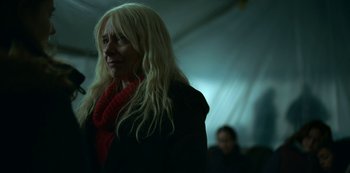 Movie still from “Lost Girls” (2020), directed by Liz Garbus – A woman with long blonde hair wearing a red scarf; Close Up shot, Low angle