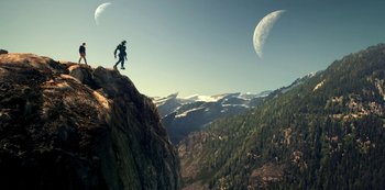 Movie still from “Lost in Space” (2018), created by Irwin Allen – A man standing on top of a mountain with mountains in the background; Extreme Wide shot, Low angle