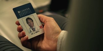Movie still from “Lost in Space” (2018), created by Irwin Allen – A person holding up an id card with a picture of a doctor on it; Extreme Close Up shot, High angle