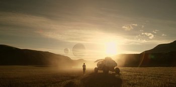 Movie still from “Lost in Space” (2018), created by Irwin Allen – A person standing in a field next to a vehicle; Extreme Wide shot, Low angle