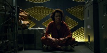 Movie still from “Lost in Space” (2018), created by Irwin Allen – A woman sitting on the ground in a room; Medium shot, High angle