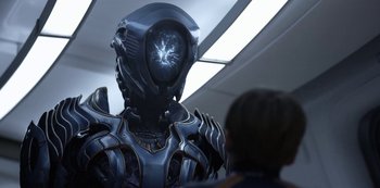 Movie still from “Lost in Space” (2018), created by Irwin Allen – A man in a suit with a helmet on his head; Medium shot, Over the shoulder angle