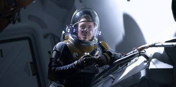 Movie still from “Lost in Space” (2018), created by Irwin Allen – A man in a space suit and a helmet; Medium shot, Overhead angle
