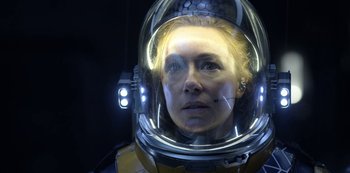 Movie still from “Lost in Space” (2018), created by Irwin Allen – A woman wearing a space helmet in a dark room; Close Up shot, Over the shoulder angle