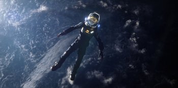Movie still from “Lost in Space” (2018), created by Irwin Allen – A man in a spacesuit floating in the sky; Extreme Wide shot, Overhead angle