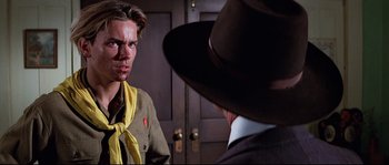 Movie still from “Indiana Jones and the Last Crusade” (1989), directed by Steven Spielberg – A young man in a scout uniform stares at an older man in a hat; Close Up shot, Over the shoulder angle